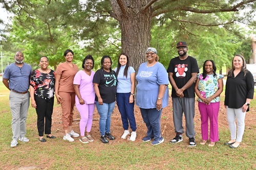 Larger Group Photo Caption: (Left to Right): (Administrators) Chris Phillips, NHA Assist. Pecan Grove Unit; Cathy Lindsey, Shift Superv. Coord.; (Winners) Courtney Taylor, Latasha Cooper, Monique Terrell, Christy Smith, Georgia Moffett, Andre McDonald, (Administrators) Tawanda Jones, NHA Assist. Hillside Unit; and Andrea Walters, NHA Paul D. Cotten, Sr. Unit.